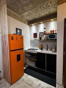 a kitchen with an orange refrigerator and a sink at Casa Once in Las Terrenas