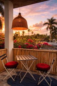 a table and two chairs on a porch with flowers at Casa Once in Las Terrenas