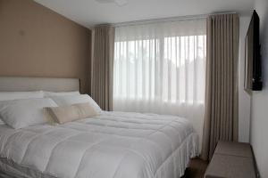 a bedroom with a large white bed and a window at Single Suite Unbeatable Location Internet b34 in Casa Blanca La Corregidora