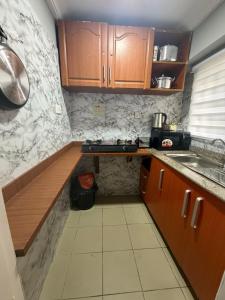eine kleine Küche mit Holzschränken und einer Spüle in der Unterkunft Royal Max in Ikeja