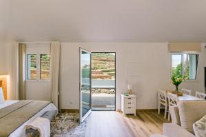 a bedroom with a bed and a desk and a mirror at Casa Ti'Vina in Caniço