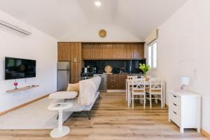 a living room with a table and a kitchen at Casa Ti'Vina in Caniço +11 photos