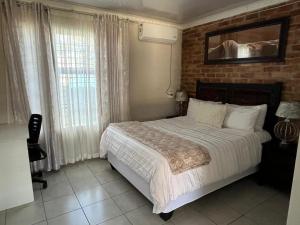 a bedroom with a bed and a brick wall at Vista Ree Guesthouse Pty Ltd in Taung