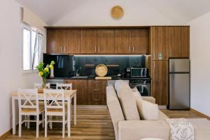a kitchen and living room with a couch and a table at Casa Ti'Vina in Caniço