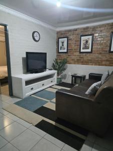 a living room with a couch and a flat screen tv at Vista Ree Guesthouse Pty Ltd in Taung