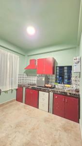 a kitchen with red cabinets and a counter top at Celeste Inn in Shillong +6 photos