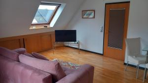 a living room with a couch and a tv at Werreufer Loft in Detmold