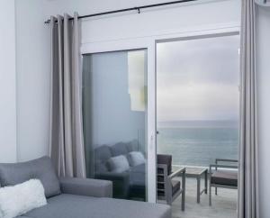 a living room with a couch and a view of the ocean at Thalassoresort UPSTAIRS in Matala