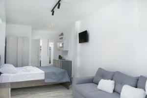 a bedroom with a bed and a couch at Thalassoresort UPSTAIRS in Matala
