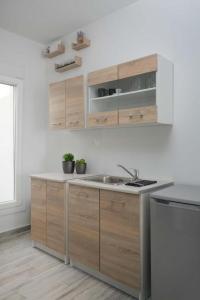 a kitchen with wooden cabinets and a sink at Thalassoresort UPSTAIRS in Matala