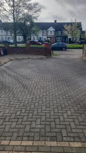 Ein gemauerter Parkplatz mit Häusern im Hintergrund in der Unterkunft Ansty Friendly in Wyken