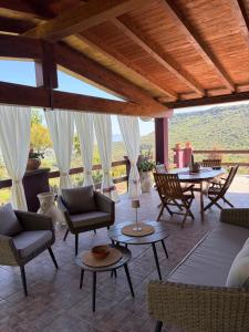 a living room with chairs and tables on a patio at Villa Veronica in Sedini