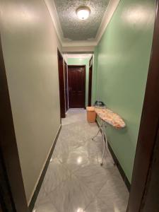 a hallway with a table in a room with green walls at Flat in Jinja City in Jinja