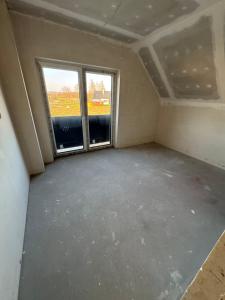 an empty room with two windows in a house at Perła pod Śnieżką in Miłków