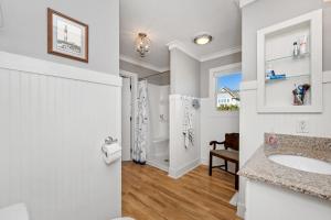 a white bathroom with a sink and a toilet at 7th Heaven by Oak Island Accommodations in Oak Island