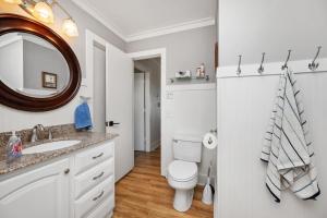 a bathroom with a toilet and a sink and a mirror at 7th Heaven by Oak Island Accommodations in Oak Island