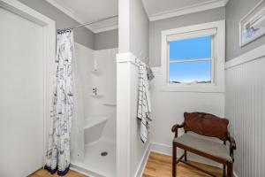 a small bathroom with a chair and a window at 7th Heaven by Oak Island Accommodations in Oak Island