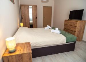 a bedroom with a bed with a television and a table at Active Homes in Veliko Tŭrnovo