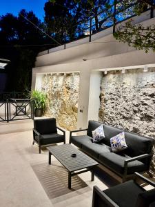 a patio with couches and a table and a stone wall at Luxury house Prestige Split in Split