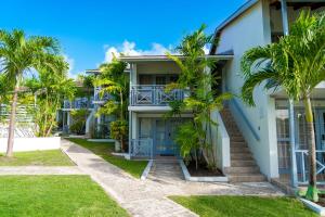 a house with palm trees in front of it at Sunset Lane Apartment Hotel in Saint James