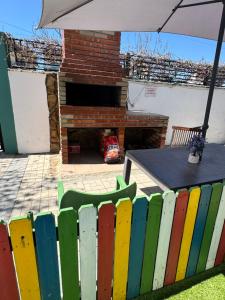 a colorful fence with a table and an umbrella at Casa Asteria - Mamaia Nord in Mamaia Sat/Năvodari