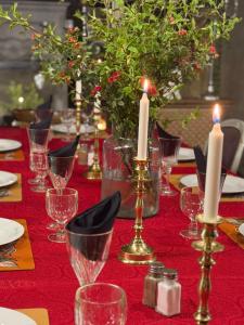 a table with a red table cloth with candles on it at L Annexe d Aubrac in Aubrac