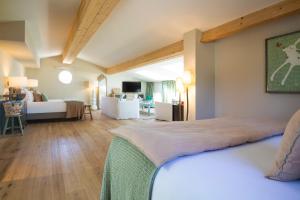a bedroom with a bed and a living room at La Bastide d'Antoine in Saint-Tropez