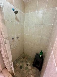ein Badezimmer mit Dusche, auf dem Boden steht eine Flasche. in der Unterkunft Finca Libelulas in Pedasí Town