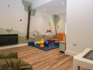 a childrens room with a mural of a tree and animals at Pod No 28 in Keswick