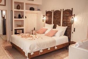 a bedroom with a large bed with a wooden headboard at La Cour Secrète - Riad & Balnéo privée in Carpentras