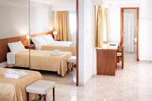 a hotel room with two beds and a mirror at Hotel Ortegal in Mar del Plata +42 photos