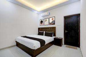a bedroom with a large bed and a black door at Hotel O White House in Rānchī