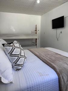 a bedroom with a bed with a pillow on it at Pousada Vô Francisco in Torres