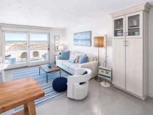 a living room with a couch and a table at Stunning Bay Views | Beach Access - Deck - Parking in Provincetown