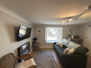 a living room with a couch and a television at Palomar in Falmouth