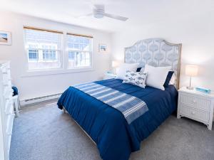 a bedroom with a blue bed and a window at Stunning Bay Views | Beach Access - Deck - Parking in Provincetown