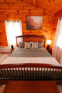 a bedroom with a bed in a log cabin at Secluded Cozy Log Cabin Villa in Creola