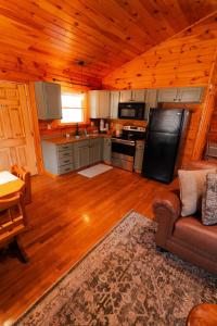 a kitchen with a couch and a stove in a cabin at Secluded Cozy Log Cabin Villa in Creola