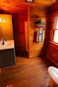 a bathroom with a sink and a toilet in a cabin at Secluded Cozy Log Cabin Villa in Creola