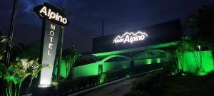 a sign for a hotel with green lights at Alpino Motel by Drops in Jundiaí