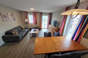 a living room with a couch and a wooden table at Apartment for vier Personen in Fehmarn - Orth in Orth