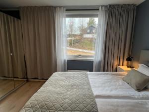 a bedroom with a bed and a large window at Haugetuft Apartments in Åmot