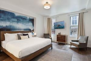 a bedroom with a large bed and a chair at Contemporary Condo Downtown Savannah in Savannah