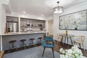 a kitchen with a blue chair and a table at Contemporary Condo Downtown Savannah in Savannah