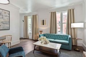 a living room with a blue couch and a table at Contemporary Condo Downtown Savannah in Savannah