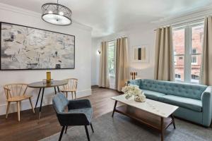 a living room with a blue couch and a table at Contemporary Condo Downtown Savannah in Savannah +21 photos