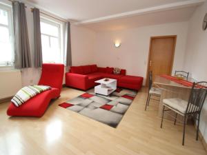 a living room with a red couch and a table at Ferienwohnung in Elbingerode by Belvilla in Elbingerode