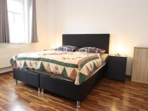 a bedroom with a bed with a green and white comforter at Ferienwohnung in Elbingerode by Belvilla in Elbingerode