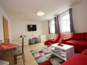 a living room with a red couch and a red chair at Ferienwohnung in Elbingerode by Belvilla in Elbingerode