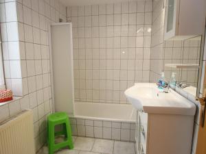 a bathroom with a sink and a bath tub with a green stool at Ferienwohnung in Elbingerode by Belvilla in Elbingerode +28 photos